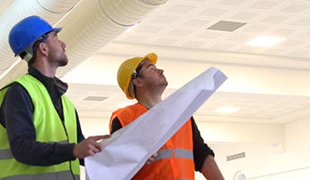 two men looking at a blueprint