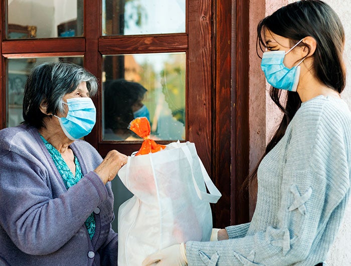 Person hand delivering food to the more vulnerable during COVID-19