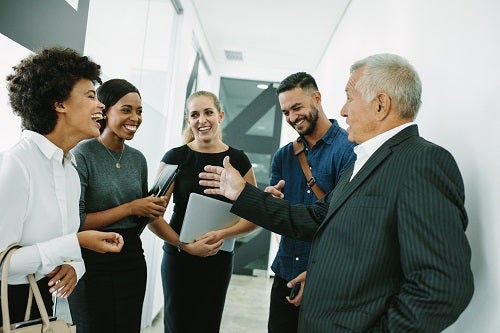 work colleagues of various ages talking in a small circle