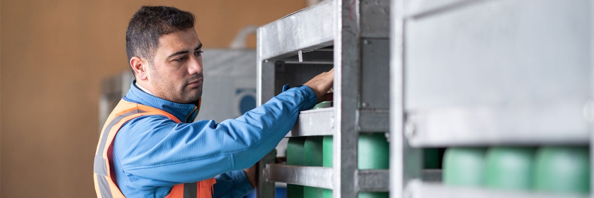 An engineer inspects medical gas cylinders