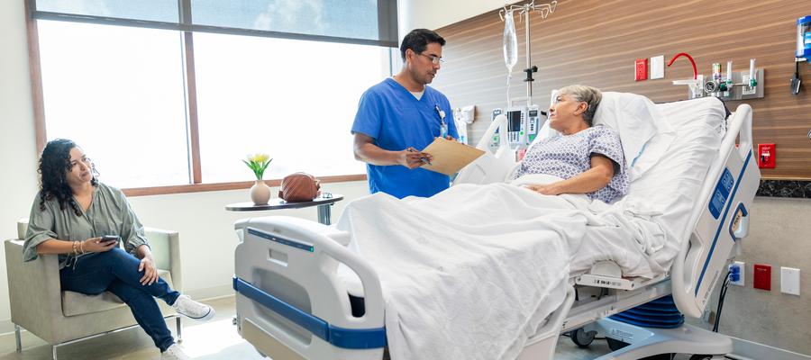 Patient in bed with doctor at bedside 