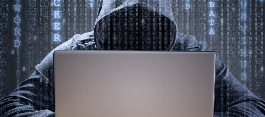 hooded figure over keyboard