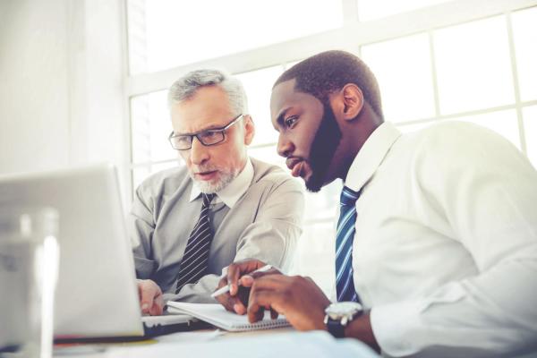 Two men looking at laptop